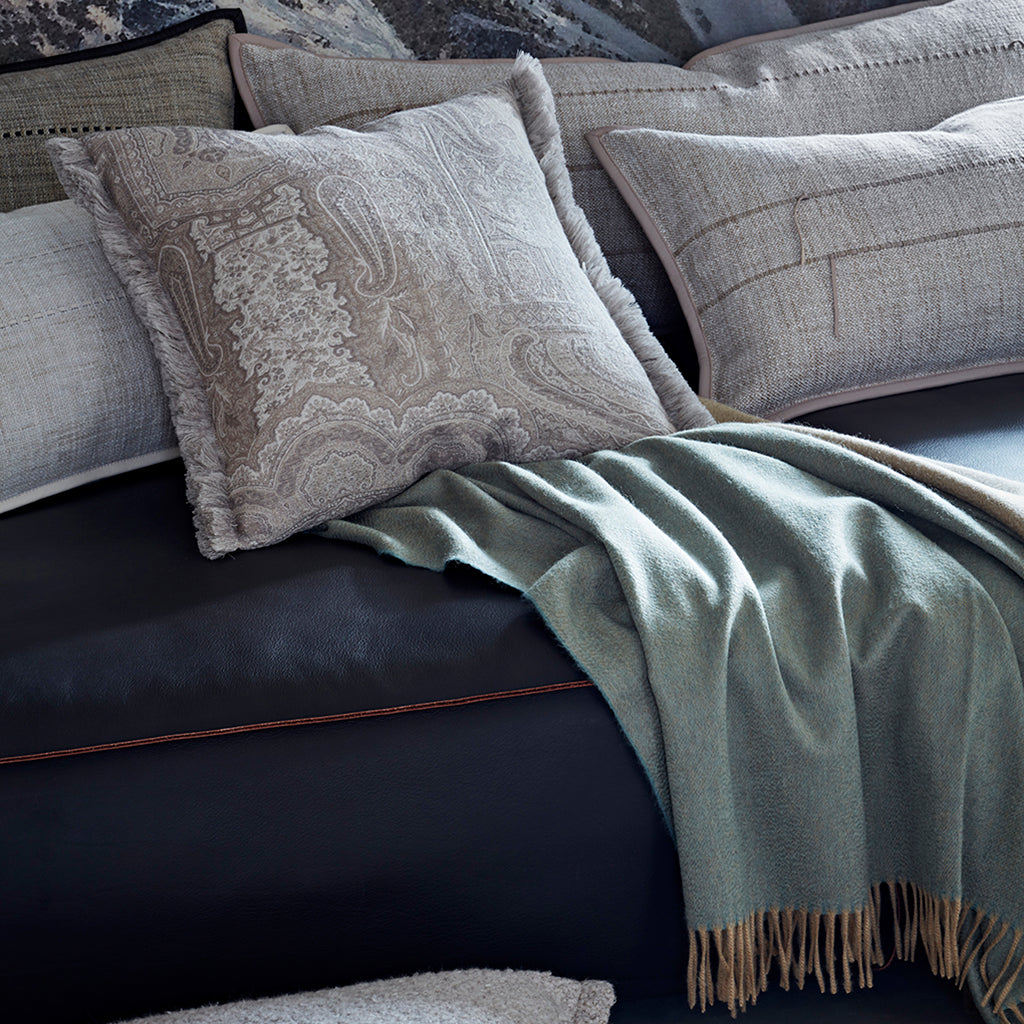Gray textured pillows and blanket on a dark sofa