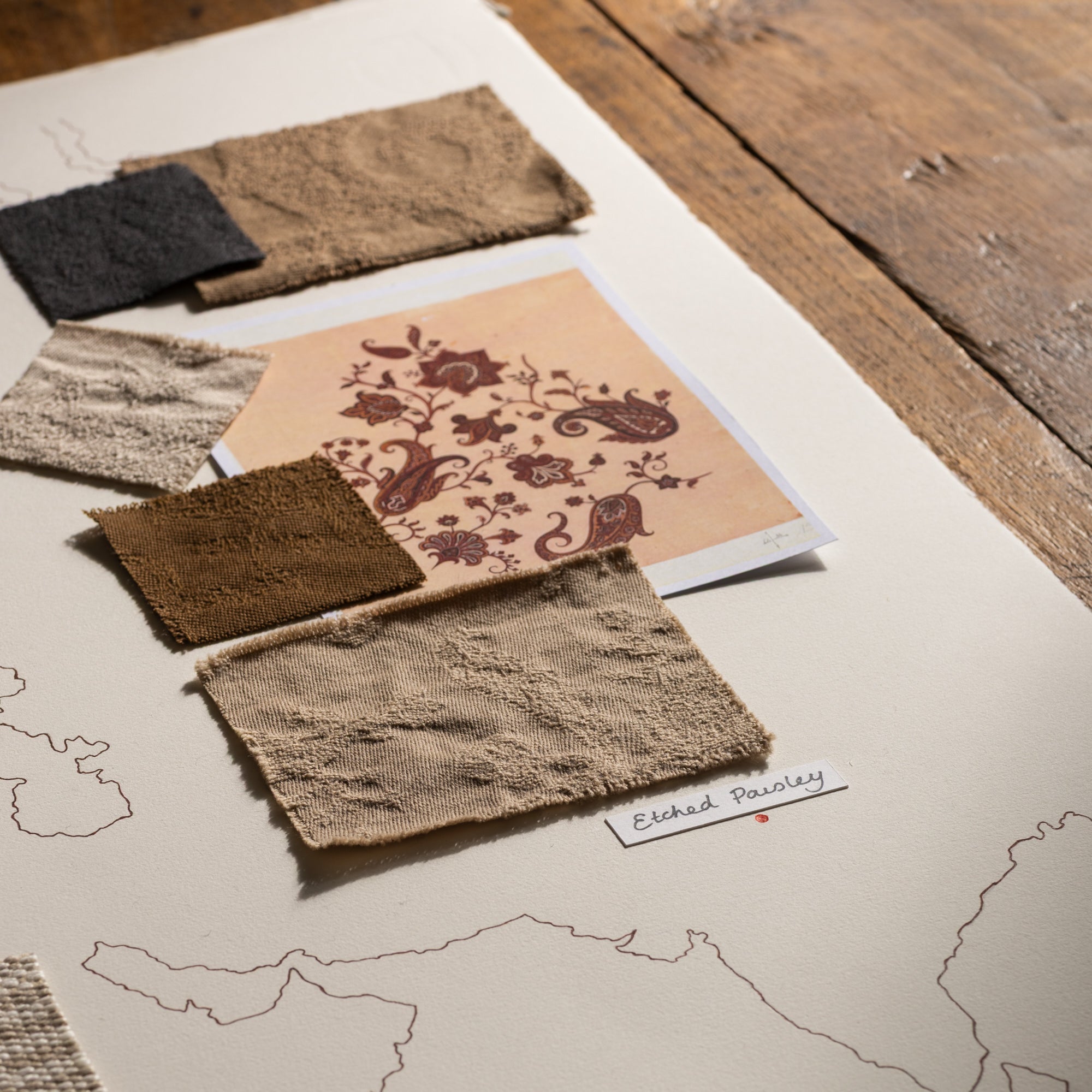 Fabric swatches arranged on a surface with a map in the background
